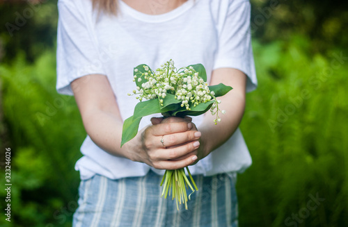 Woman holding a bouquet of lilly of valley flowers