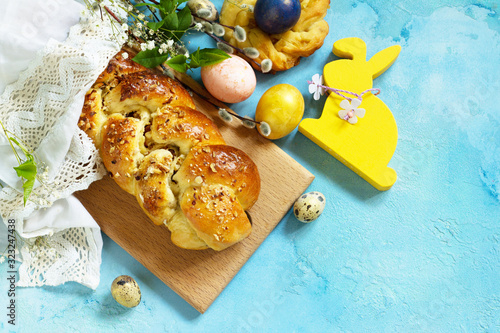 Easter sweet bread with colored eggs and traditional Italian Easter bread ringson a blue stone concrete tabletop. Top view flat lay background. photo