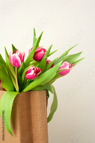 Fototapeta Naklejka Na Ścianę i Meble -  pink tulips bouquet in gift bag, 8 march, women day, valentines day, spring time.