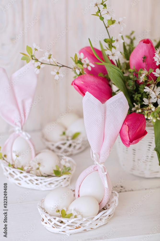 Happy easter. Decor and table setting of the Easter table is a vase with pink tulips and dishes of pink and green color. Happy easter. Decor and table setting of the Easter table is a vase with pink tulips and dishes of pink and green color.