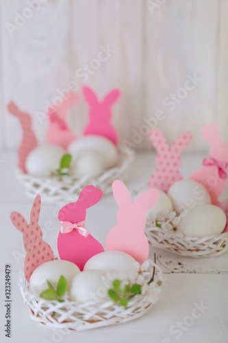 Happy easter. Decor and table setting of the Easter table is a vase with pink tulips and dishes of pink and green color.