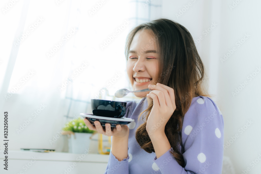portrait happy young asian pretty woman smiling and holding cup of coffee sitting on bed and relax at morning in bedroom at home, drinking coffee, lazy day, good morning and joyful weekend concept portrait happy young asian pretty woman smiling and holding cup of coffee sitting on bed and relax at morning in bedroom at home, drinking coffee, lazy day, good morning and joyful weekend concept