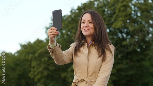Laughing woman creating content using smartphone
