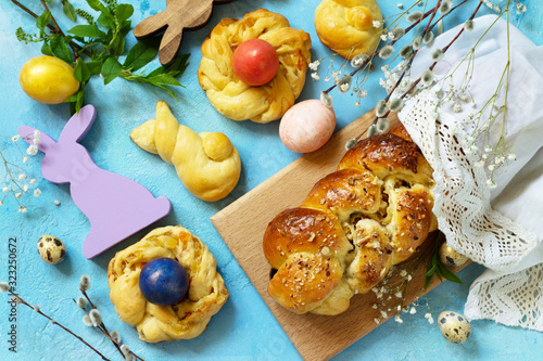 Easter sweet bread with colored eggs and traditional Italian Easter bread ringson a blue stone concrete tabletop. Top view flat lay background. photo