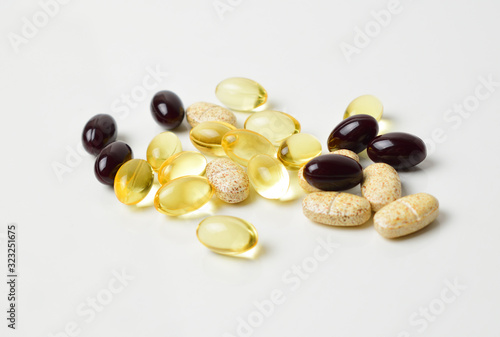 Scattered pills on a white background. Astaxanthin, fish oil and vitamins. Close-up.