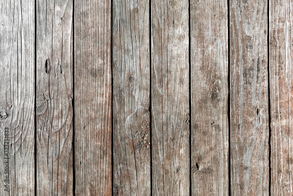 Background of old, weathered, dried-up, vertical wooden planks with deep cracks and knots. intricate pattern. Texture of wood. Free text space