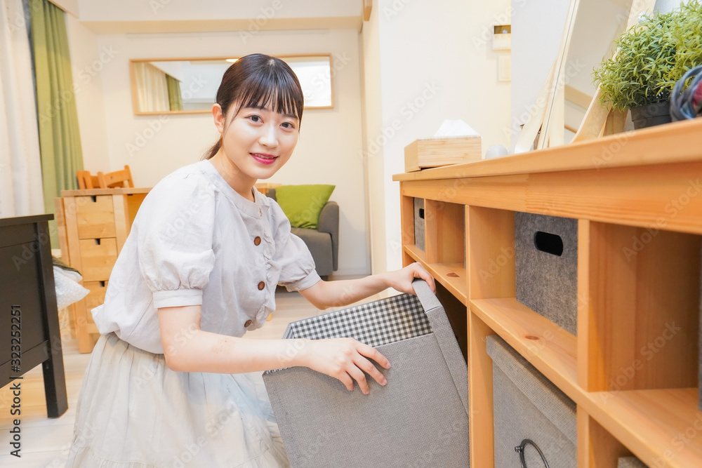 棚の片付けをする若い女性