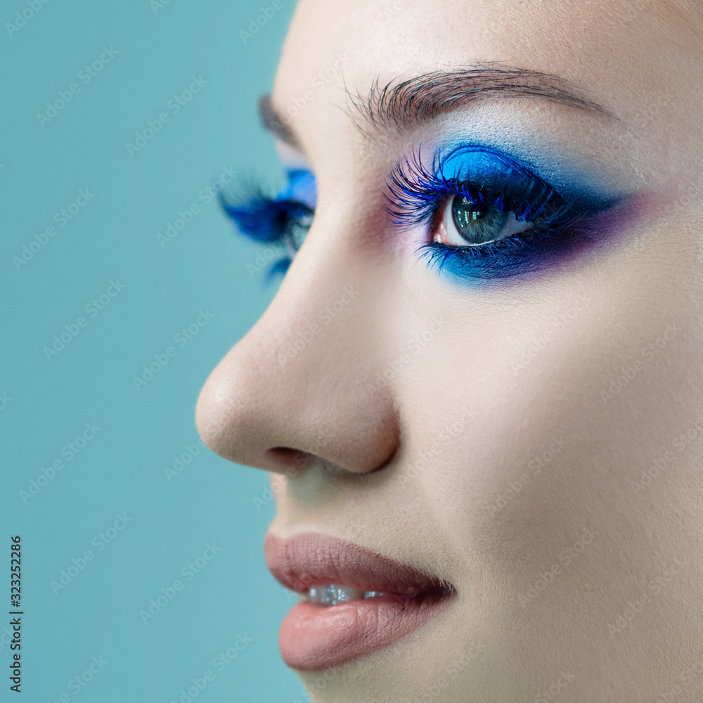 Fototapeta premium Glamorous bright eye makeup using the trend color classic blue, women's eyes close-up.
