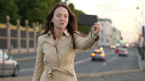 Woman blogger recording vlog against city street and road traffic