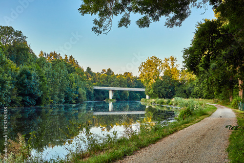 Image of La Villaine River with the D38 bridge, trees and towpath photo