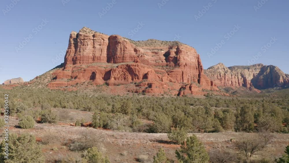 A drone flying past trees towards Courthouse Butte rock formation in Sedona, Arizona. A drone flying past trees towards Courthouse Butte rock formation in Sedona, Arizona.