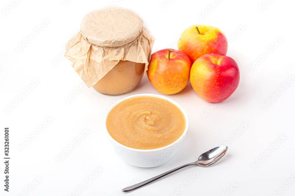 Fresh homemade applesauce in white bowl and jar with fruit puree on white table. The concept of proper nutrition and healthy eating. Organic and vegetarian food. Baby food. Copy space for text Fresh homemade applesauce in white bowl and jar with fruit puree on white table. The concept of proper nutrition and healthy eating. Organic and vegetarian food. Baby food. Copy space for text