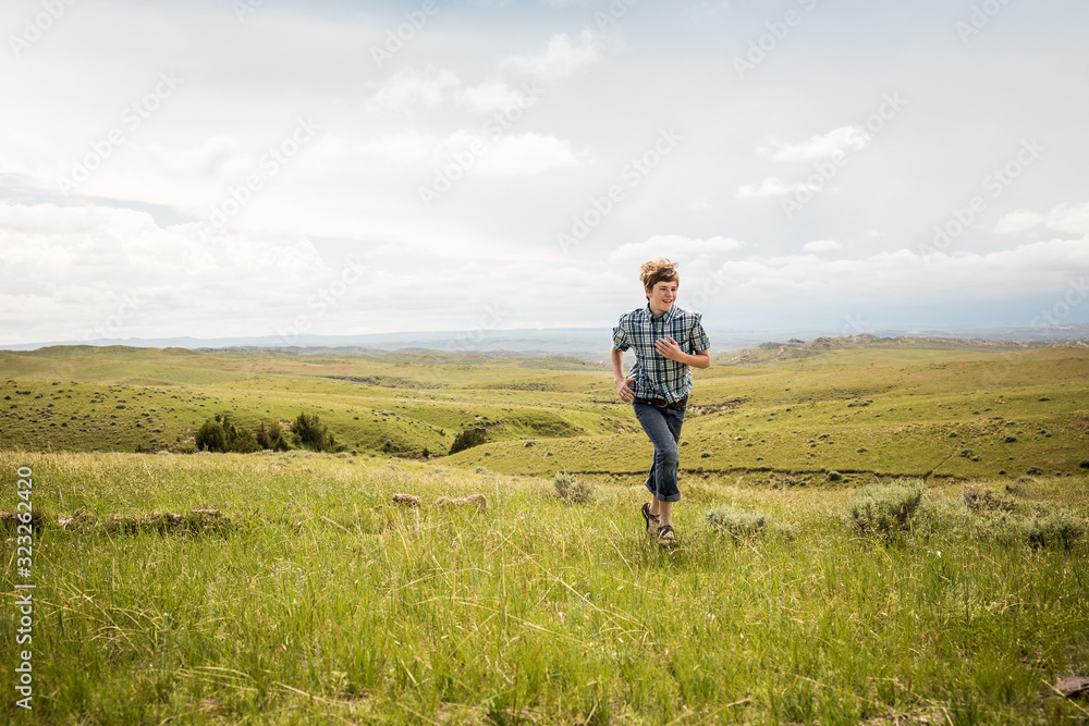 Young boy hiking through rural prairie setting. Cody, Wyoming, USA Young boy hiking through rural prairie setting. Cody, Wyoming, USA
