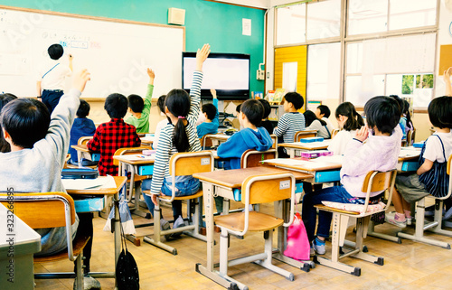 小学校の教室で手を挙げる生徒 photo