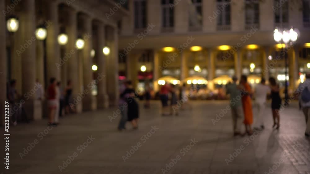 Parisians and tourists dance elegantly in one of the squares of Paris. Bright shop Windows, beautiful building facade decorated with columns, in the background. Outdoor dancing, summer evening, Paris. Parisians and tourists dance elegantly in one of the squares of Paris. Bright shop Windows, beautiful building facade decorated with columns, in the background. Outdoor dancing, summer evening, Paris.
