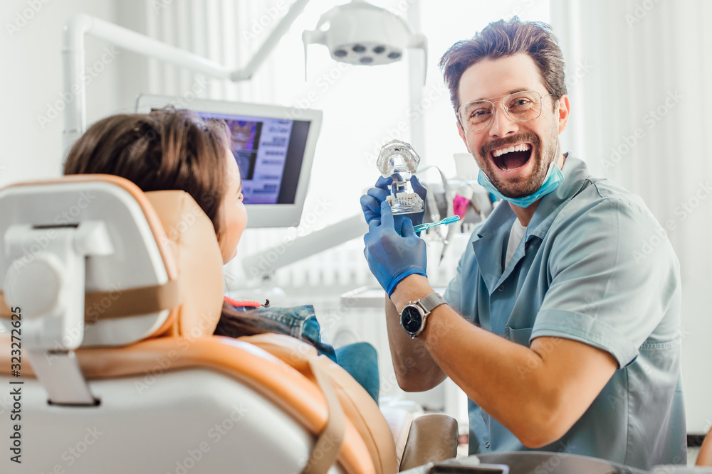 Teeth layout for the dentist with a toothbrush in dentist hands. Teeth layout for the dentist with a toothbrush in dentist hands.