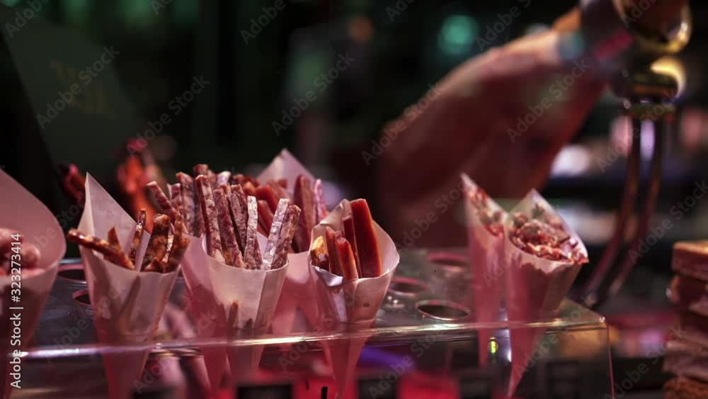 Pan shot left to right slices of jamon for sale the shop window of european meat shop. Gimbal pan shot of shop glass with pieces of meat for sale Pan shot left to right slices of jamon for sale the shop window of european meat shop. Gimbal pan shot of shop glass with pieces of meat for sale