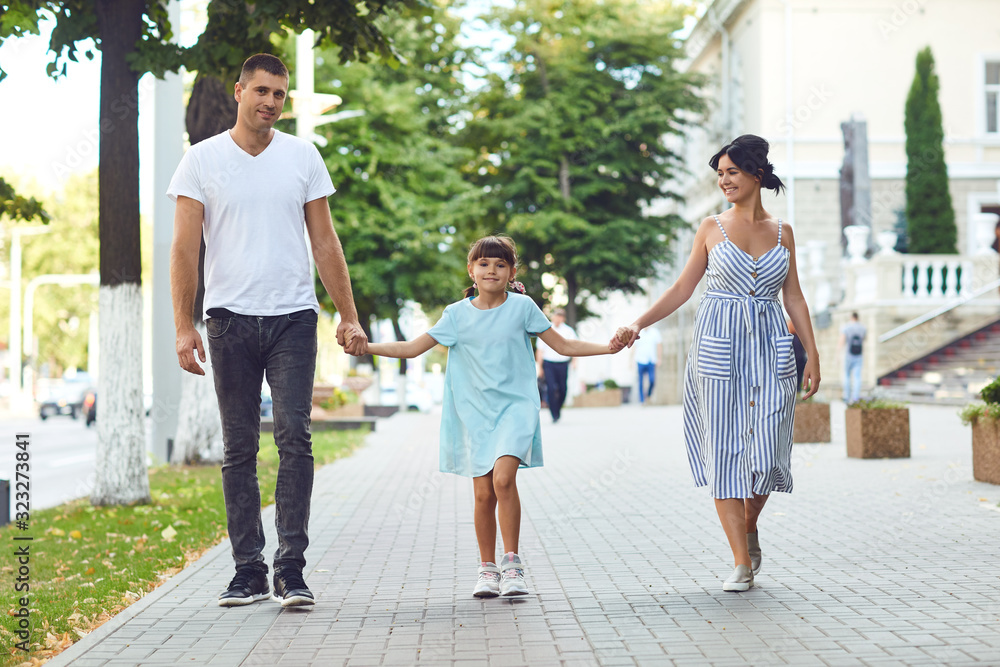 Happy family walking together in the street of the city Happy family walking together in the street of the city