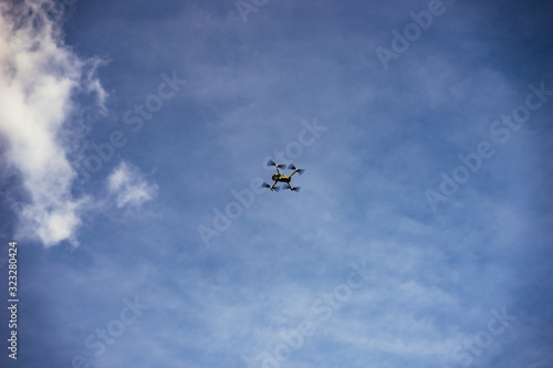 Drone flying overhead in a blue hazy sky