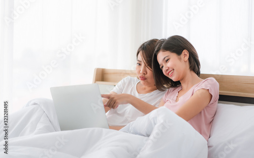 Attractive two woman in white shirt using laptop and smiling at morning