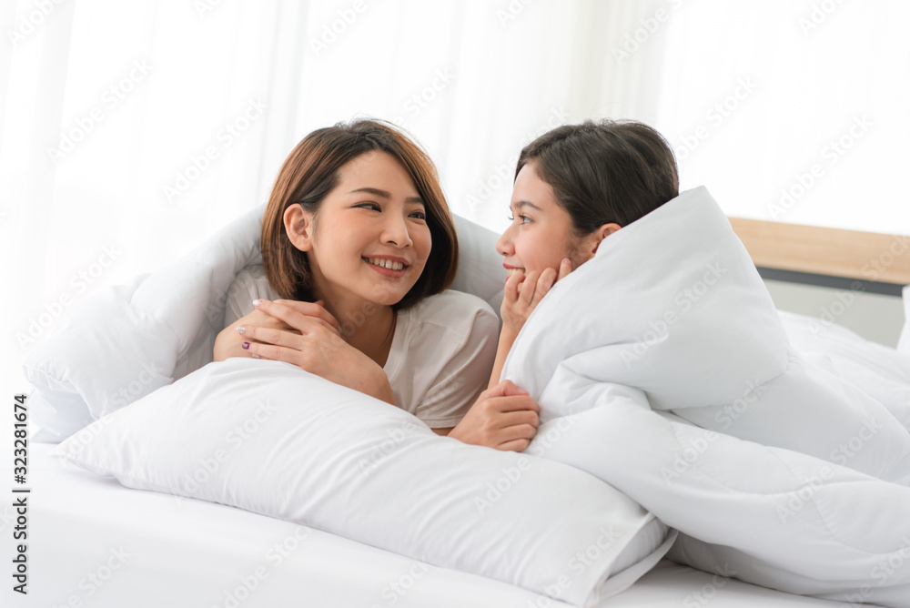 Asian lesbian LGBT Couple warm hug on bed in bedroom with laughing moment,love win concept,beautiful attractive happiness moment Asian lesbian LGBT Couple warm hug on bed in bedroom with laughing moment,love win concept,beautiful attractive happiness moment