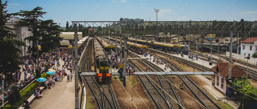 Aerial view of the train station in Simferopol, Ukraine, during the summer holidays. Platforms of the station are filled with travelers going to different destinations.