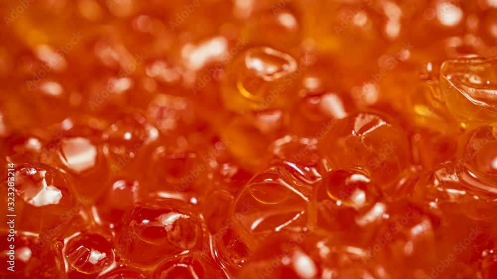 Appetizing background of red caviar. Salmon or trout caviar is laid out in a plate and rotates Appetizing background of red caviar. Salmon or trout caviar is laid out in a plate and rotates