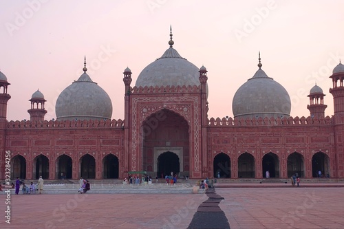 Lahore, Pakistan - 09.09.2019: People gathering at Badshahi mosque in dark sunset light, Pakistan 2019 photo