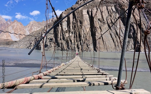 Hussaini Hanging suspension Bridge in Hunza, the most dangerous bridge in the world with the Passu cornes in background