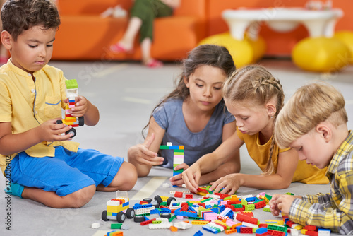 Kids are in entertainment center. Children playing constructor toys in playroom. Kids activity center.