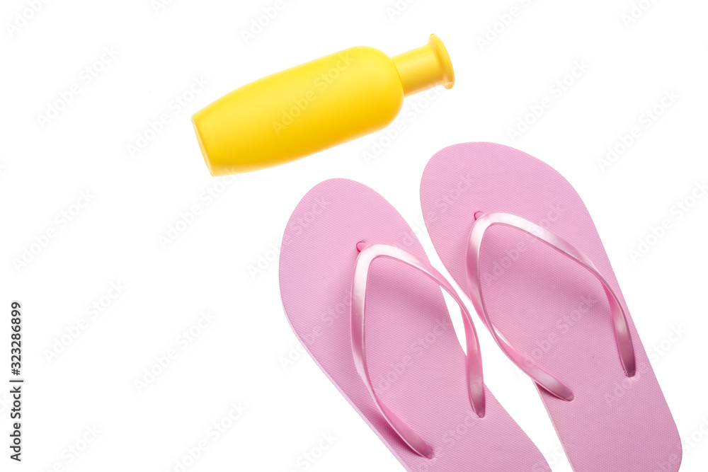 Plastic flip flops, tanning cream bottle isolated on white background. Beach Vacation Concept Plastic flip flops, tanning cream bottle isolated on white background. Beach Vacation Concept