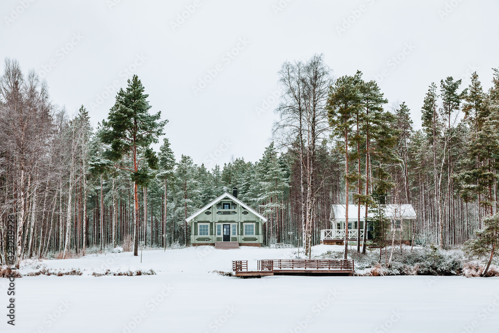 Wooden cottage in snow covered forest in Finland.