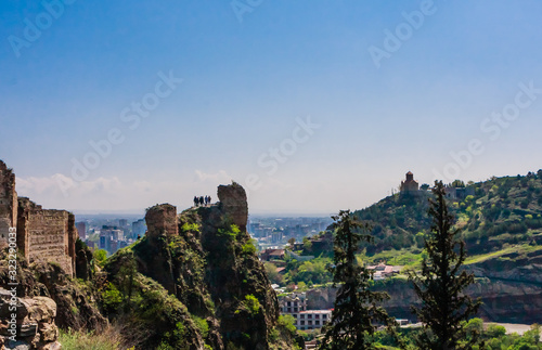 Tourists looking down who climbed ruins at Narikala- an ancient fortress overlooking the capital of Georgia. Tbilisi, Georgia