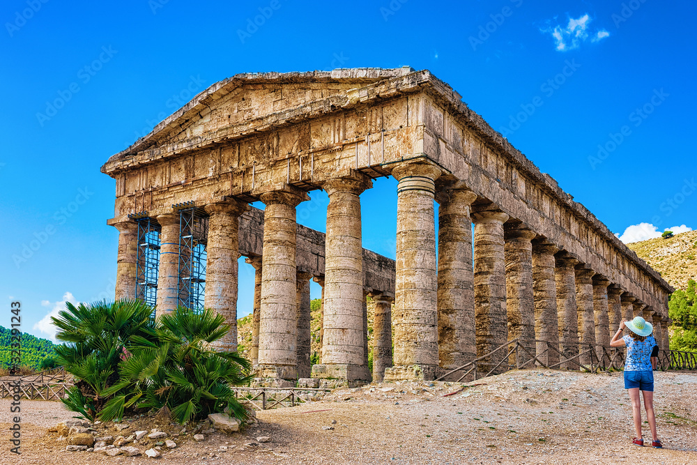 Fototapeta premium Woman takng photos at Doric temple in Segesta on Sicily