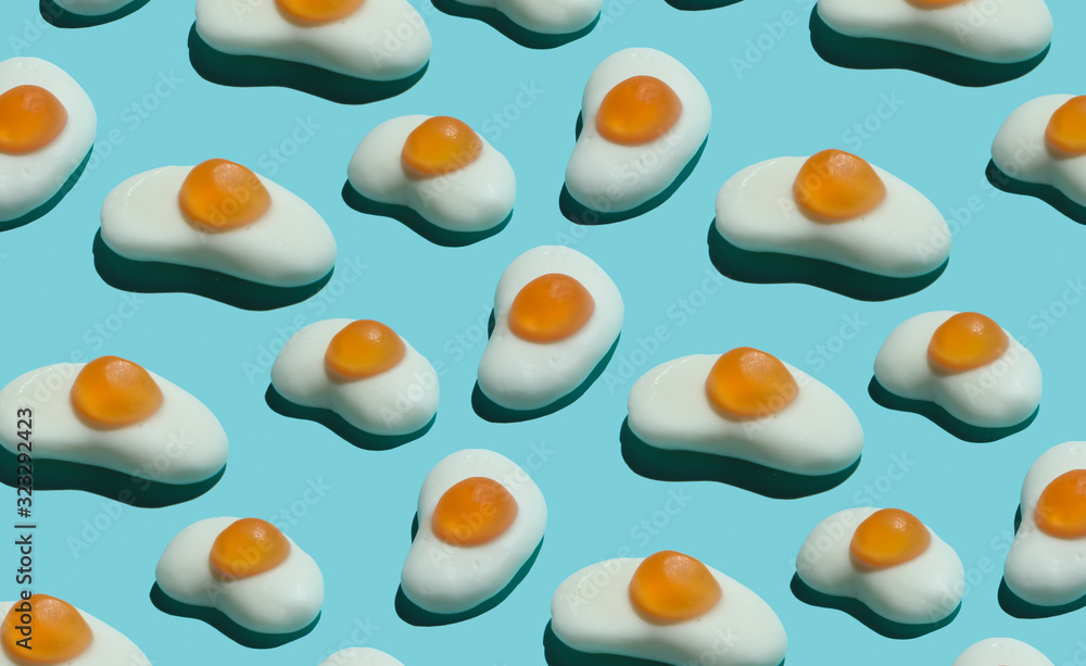 Pop art background. A lot of marmalade fried eggs on blue pastel background. Minimalism food still life Pop art background. A lot of marmalade fried eggs on blue pastel background. Minimalism food still life