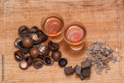 Two shot of home-brewed whiskey stand on a wooden board