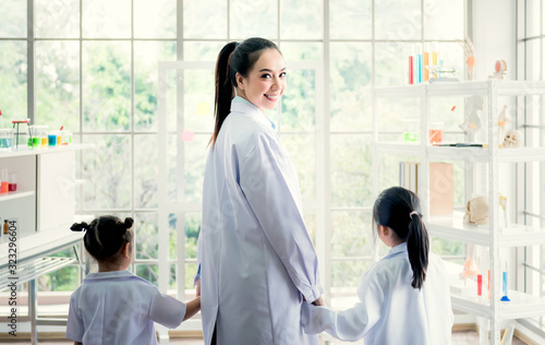 Portrait images of pretty Asisn female teacher Holding hands to kindergarteners In the classroom know and experiment in science, to education and children concept. photo