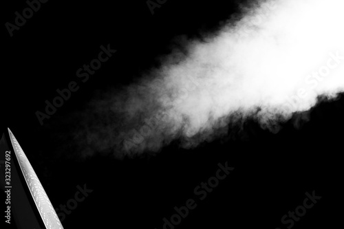 Electric iron with steam isolated on black background.