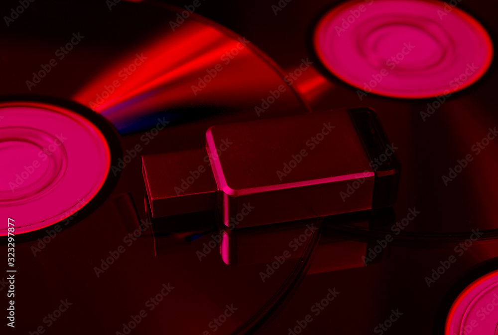 USB flash drive on CDs. Pink neon light