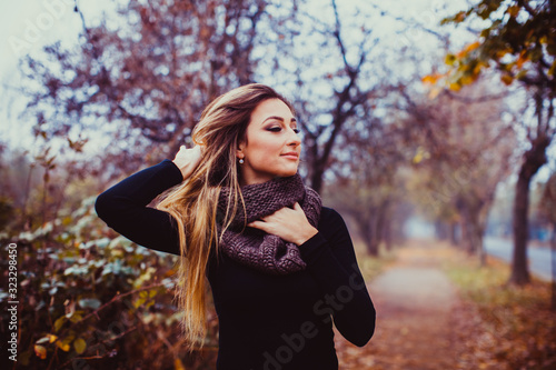 Attractive woman with healthy long hair enjoying autumn day.