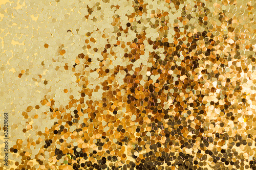 Gold glitter texture. Celebratory background. Golden explosion of confetti.