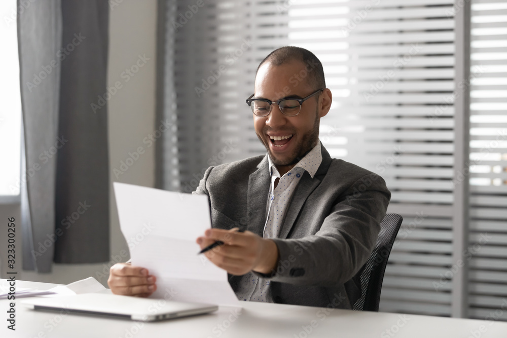 Excited businessman feel euphoric by good news in letter Excited businessman feel euphoric by good news in letter