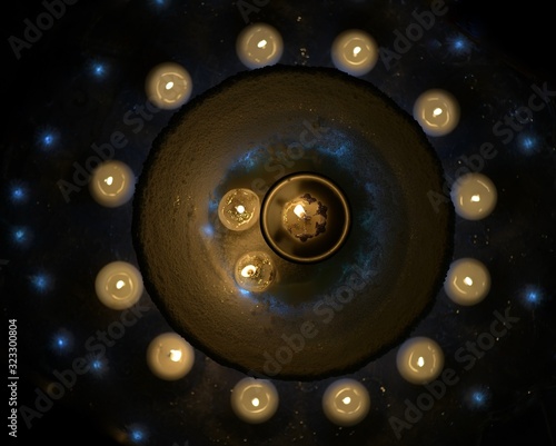 candles around a snow-covered vase in the darkness