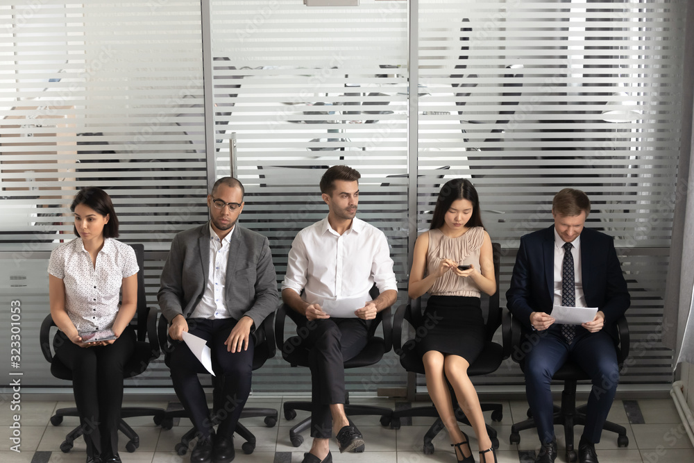 Focused diverse candidates in queue wait for job interview Focused diverse candidates in queue wait for job interview