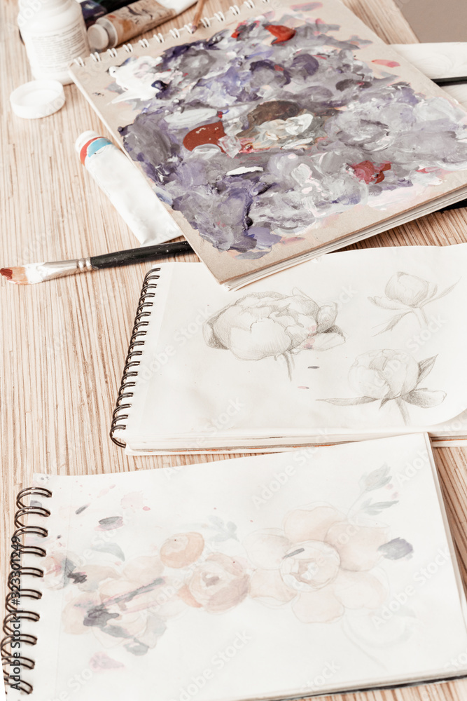 Tools of the artist. Palette, paints, brushes during use. Creativity and painting.