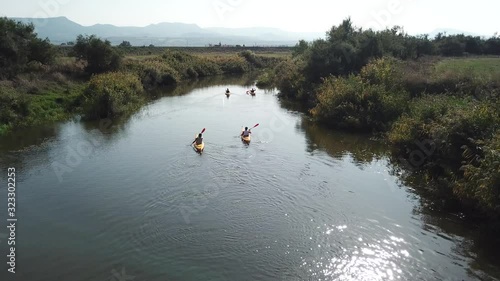 Drone video of kayaks on Coghinas River with mountains in the background. Beautiful Sardinia, Italy.  photo