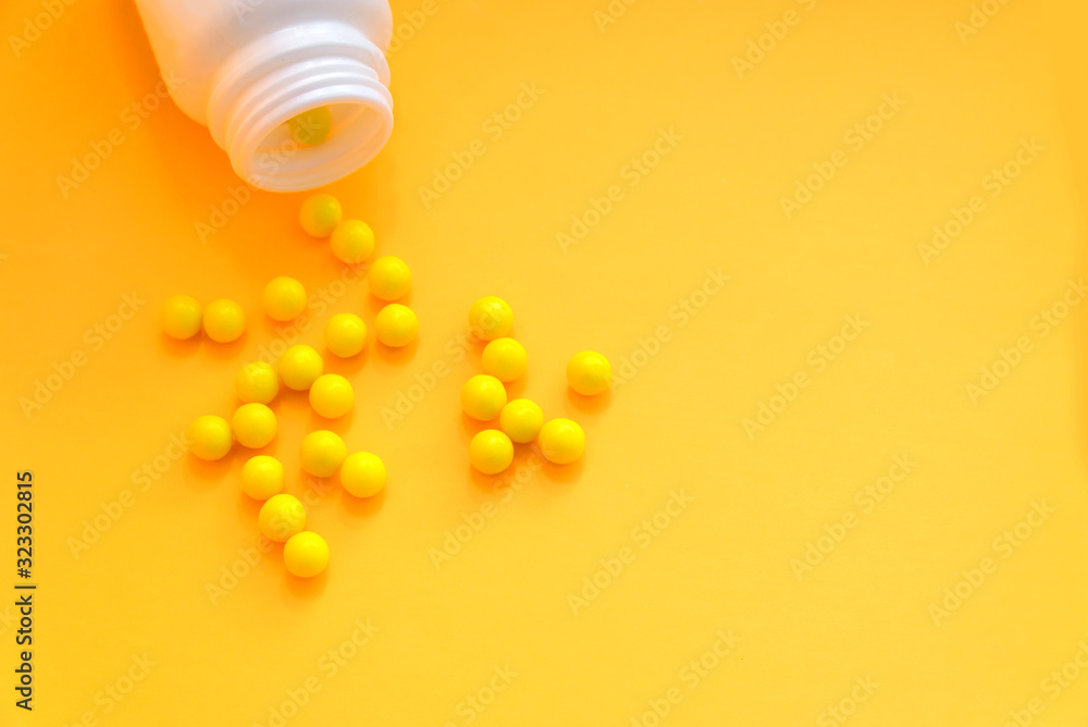 Yellow pills, vitamin C on a yellow background copy space. Concept of medicine, health and body care Yellow pills, vitamin C on a yellow background copy space. Concept of medicine, health and body care