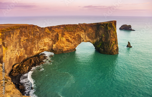 Natural lava arch in the sea. Cape Dyrholaey, coast of Iceland. Popular tourist attraction. Beauty world. photo