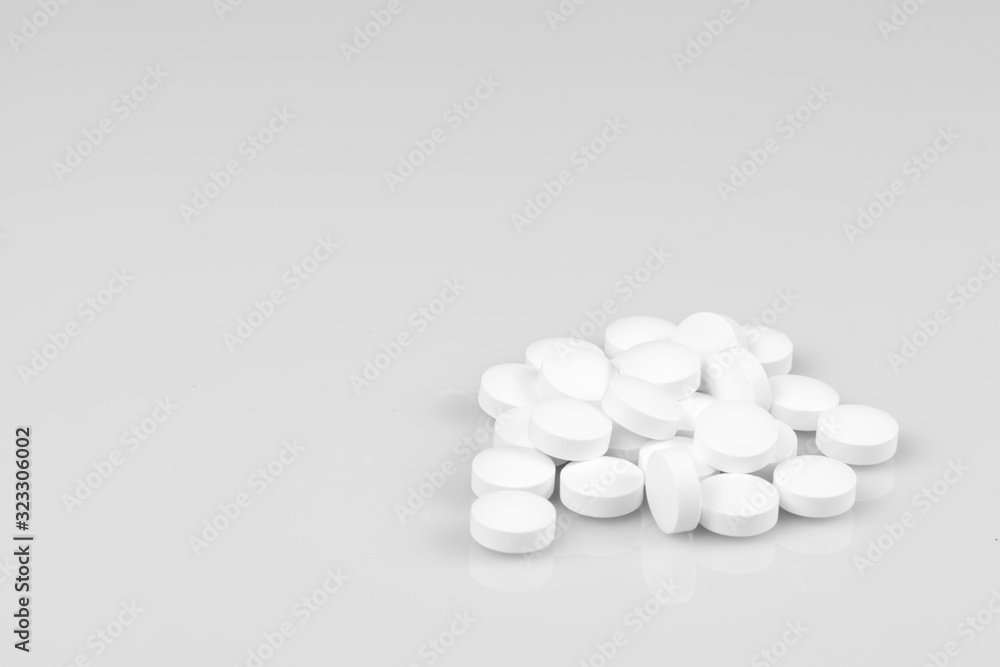 White pills on grey background with free space. White pills on grey background with free space.