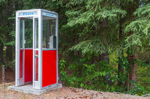 A red phone booth in the forest in Slana, Alaska photo